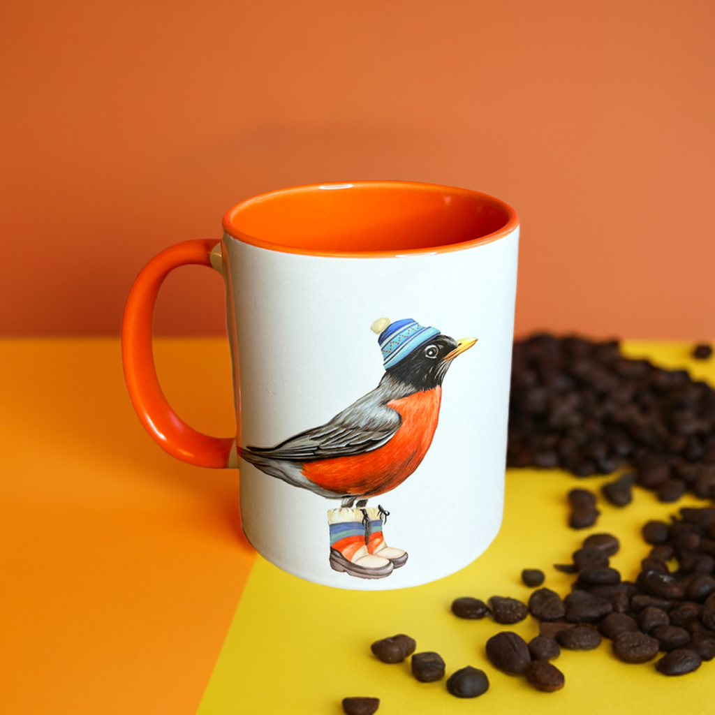 American Robin mug with orange accents with orange backdrop and coffee beans